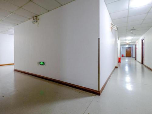 an empty hallway with a white wall in a building at Shijia Inn On the Bund in Shanghai