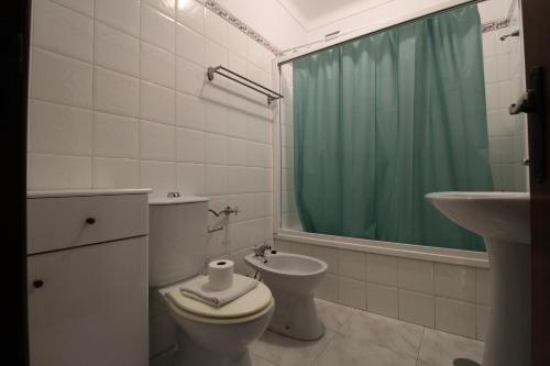 a bathroom with a toilet and a sink and a shower at Casa Cor-de-Rosa in Vila Nova de Milfontes
