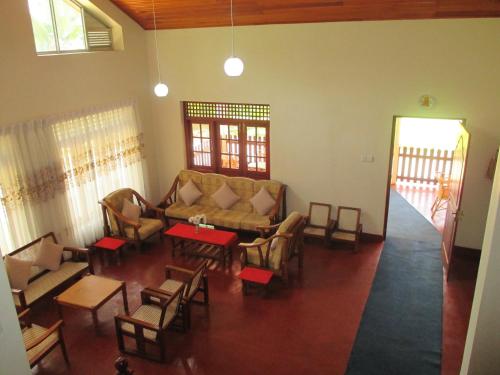 a living room with a couch and a table and chairs at Alfred Colonial Bungalow & Spice Garden in Kobbekaduwa