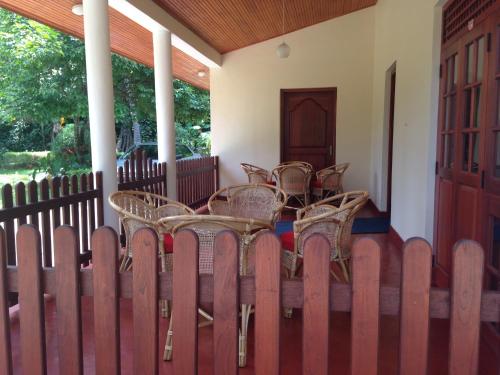 a group of chairs and tables on a porch at Alfred Colonial Bungalow & Spice Garden in Kobbekaduwa