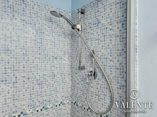 a shower in a bathroom with blue tiles at Lamante apartment in Lucca in Lucca