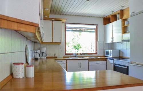 a kitchen with white cabinets and a wooden counter top at Four-Bedroom Holiday Home In Grasted in Græsted