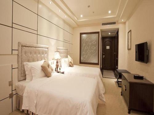 a bedroom with two beds and a desk and a television at Chengdu Haotian Guotai Hotel in Chengdu