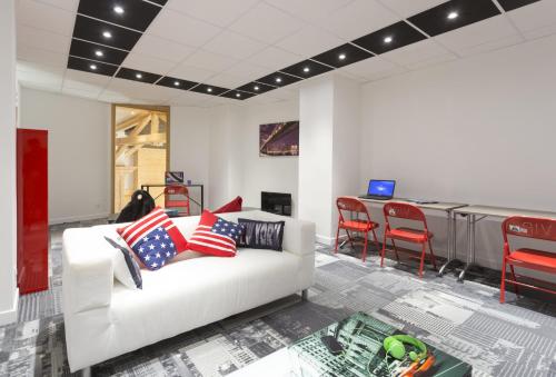 a living room with a white couch and red chairs at Hôtel Club mmv Les Arolles **** in Val Thorens