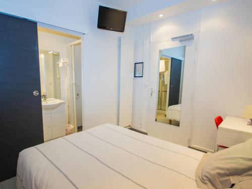 a white bedroom with a bed and a mirror at Hôtel Saint Jean in Tours