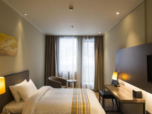Una cama o camas en una habitación de Home Inns Plus Shanghai Xujiahui Branch