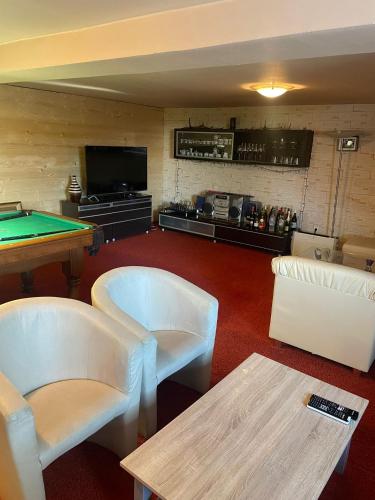 a room with a pool table and couches at Chalupa Zákopčie in Zákopčie