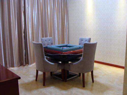 a ping pong table with two chairs in a room at Shanghai Jinghang Hotel in Shanghai