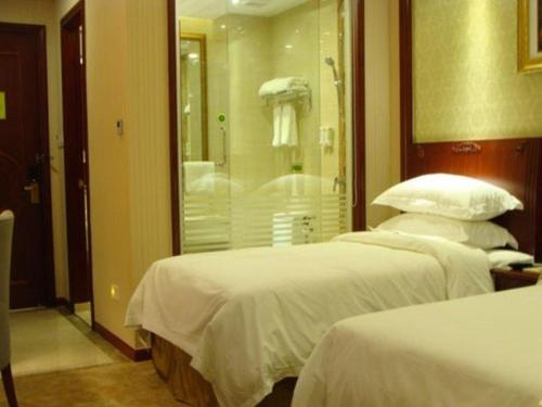 two beds in a hotel room with a shower at Shanghai Jinghang Hotel in Shanghai