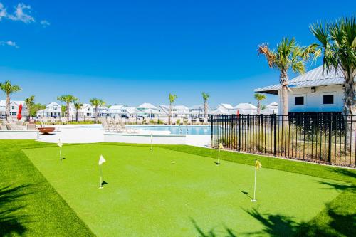 a golf course in front of a pool with palm trees at Sandy Cheeks in Orange Beach