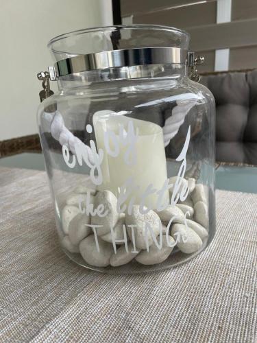 a glass jar with a candle and shells in it at Ferienwohnungen Im Kimmelreich in Irsch