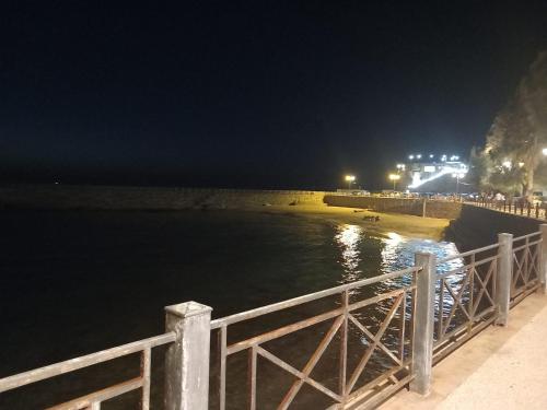 a fence next to the water at night at Blueinfinityroom in Pizzo