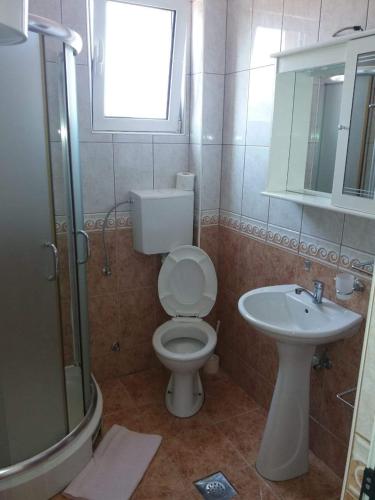 a bathroom with a toilet and a sink at Apartmani Simonovic in Sutomore