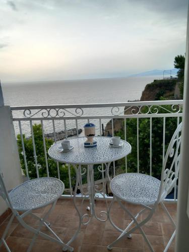 a table and chairs on a balcony with the ocean at Blueinfinityroom in Pizzo