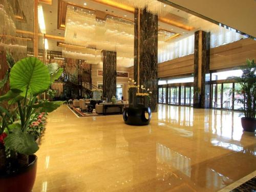 a lobby with a large lobby with potted plants at Zhangjiagang Zhonglian GDH International Hotel in Zhangjiagang