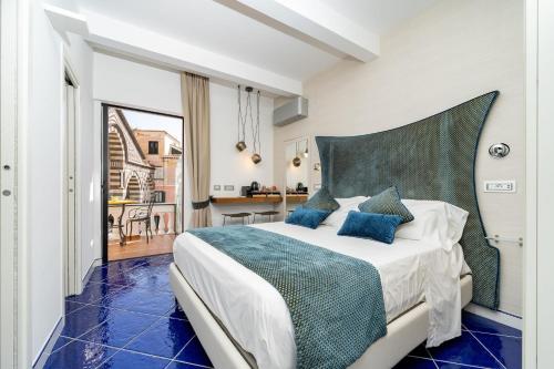 a bedroom with a large bed with blue pillows at La Suite Del Cavaliere in Amalfi