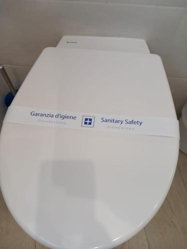 a white toilet seat with a sticker on it at Blueinfinityroom in Pizzo