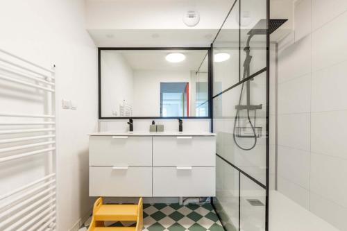 une salle de bain avec un lavabo et un miroir dans l'établissement OIQIA • Pop Factory, à Bussy-Saint-Georges