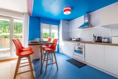 une cuisine bleue avec des chaises rouges et une table dans l'établissement OIQIA • Pop Factory, à Bussy-Saint-Georges