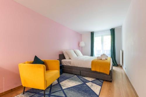- une chambre avec un lit et une chaise jaune dans l'établissement OIQIA • Pop Factory, à Bussy-Saint-Georges