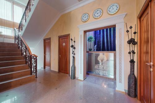 a hallway with stairs and clocks on the wall at Hotel Alberia in Pyatigorsk
