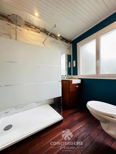 une salle de bain avec une baignoire, des toilettes et un lavabo dans l'établissement L'Authentique - Charmante maison, à La Tremblade