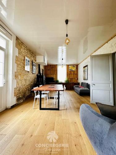 une salle à manger avec une table et un salon dans l'établissement L'Authentique - Charmante maison, à La Tremblade