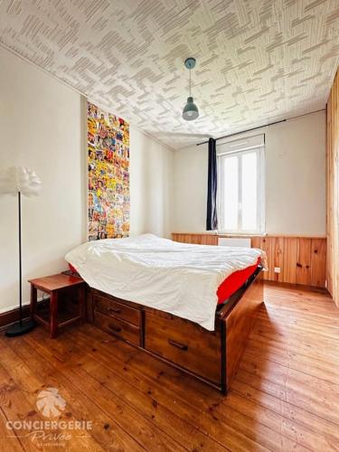 une chambre avec un grand lit dans une pièce dans l'établissement L'Authentique - Charmante maison, à La Tremblade