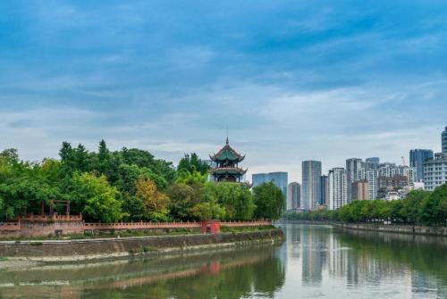 a river with a pagoda in the middle of a city at 7 Days Inn Chengdu Sichuan University South Railway Station in Chengdu