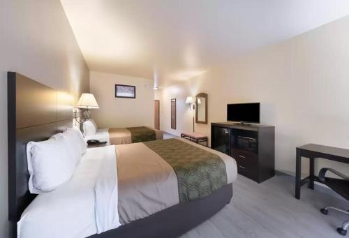 a hotel room with a large bed and a desk at Econo Lodge Inn & Suites Bridgeport in Bridgeport