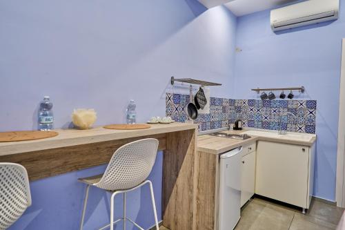 eine Küche mit einer Theke und zwei Stühlen darin in der Unterkunft La Marina in Neapel