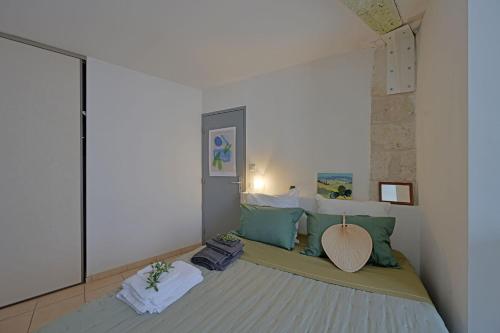 - une chambre avec un lit doté d'oreillers verts et blancs dans l'établissement Le Provençal - HYPER CENTRE - WIFI, à Avignon