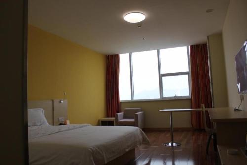 a hotel room with a bed and a window at 7 Days Inn Qingdao Liaoyang West Road Xinye Plaza Metro Station in Qingdao