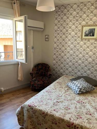 une chambre avec un lit, une chaise et une fenêtre dans l'établissement Coquette maison de ville au centre du village - V0787, à Vias