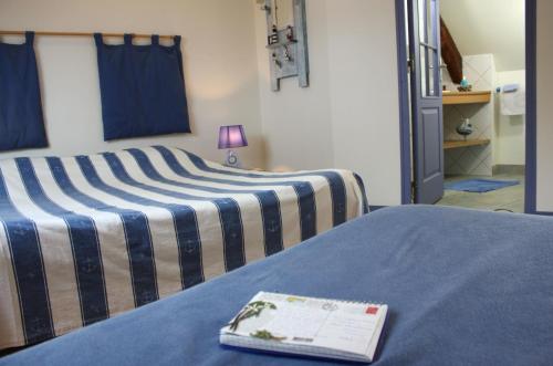 a hotel room with two beds with a book on them at Les Keriaden's in Pleudihen