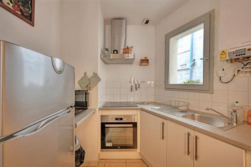 une cuisine avec un réfrigérateur en acier inoxydable et un évier dans l'établissement Le Provençal - HYPER CENTRE - WIFI, à Avignon