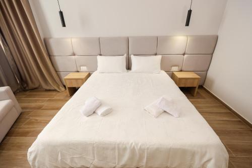 a bedroom with a large white bed with two pillows at Blue Studios in Golem