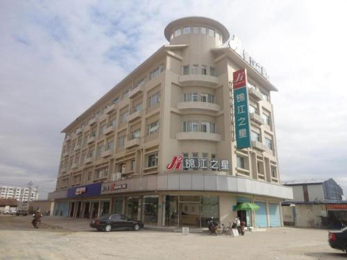 a large building with a car parked in front of it at GreenTree Inn Fujian Fuzhou Software Park River View Business Hotel in Fuzhou