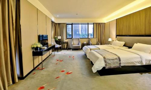 a large hotel room with two beds and a television at Shantou Grandtide Hotel in Shantou