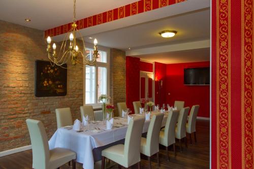 a dining room with a white table and chairs at Hotel de Weimar in Ludwigslust