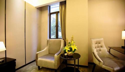 a room with two chairs and a table and a window at Shantou Grandtide Hotel in Shantou