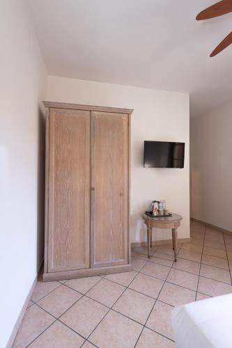 a room with a wooden cabinet and a table at Hotel Tornielli 9 by LVG Hotel Collection in Novara