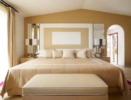 a large bedroom with two beds and a large window at Hotel & SPA des Pecheurs in Bonifacio