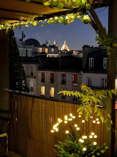 d'un balcon éclairé offrant une vue sur la ville. dans l'établissement Room with terrace and view of Sacré Coeur, à Paris