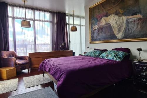 - une chambre avec un lit violet et une peinture murale dans l'établissement Room with terrace and view of Sacré Coeur, à Paris