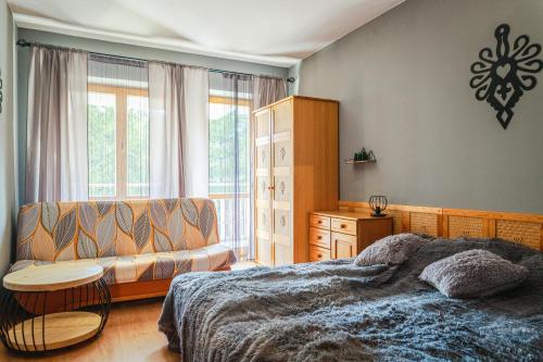 扎科帕内VisitZakopane - Mohito Apartment的带床和沙发的卧室