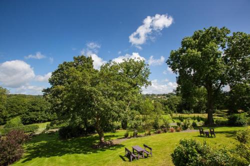a park with benches and trees on a field at Penbontbren Luxury Bed and Breakfast in Aberporth