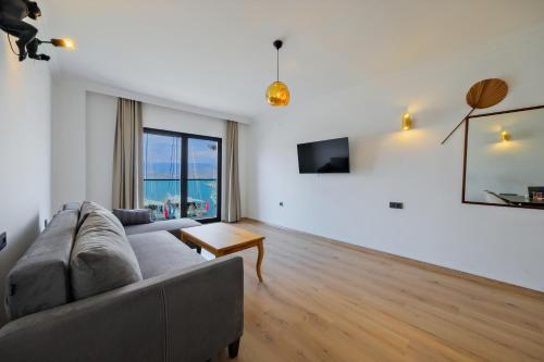 a living room with a couch and a table at Körfez Residence in Fethiye