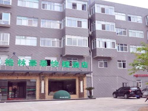 a tall building with green writing on it at GreenTree Inn Ganzhou Sankang Temple DaRunFa Express Hotel in Ganzhou