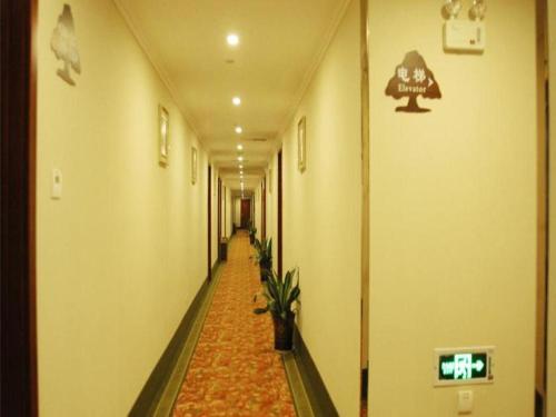 a hallway with a long hallway with plants in it at GreenTree Inn Suzhou Shihu Suli Road Express Hotel in Suzhou